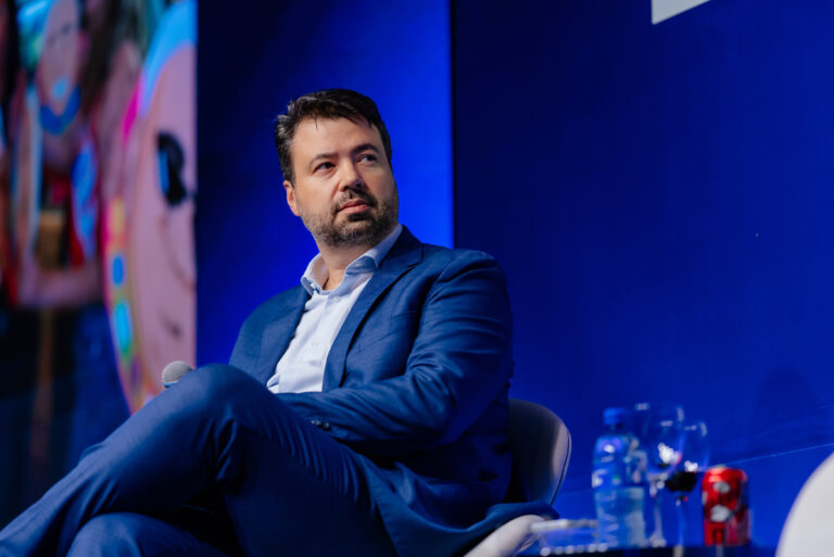 Marcelo Vitorino, de blazer azul, sentado durante painel de debate em evento