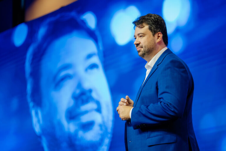 Marcelo Vitorino em palestra, com a sua imagem projetada no telão ao fundo